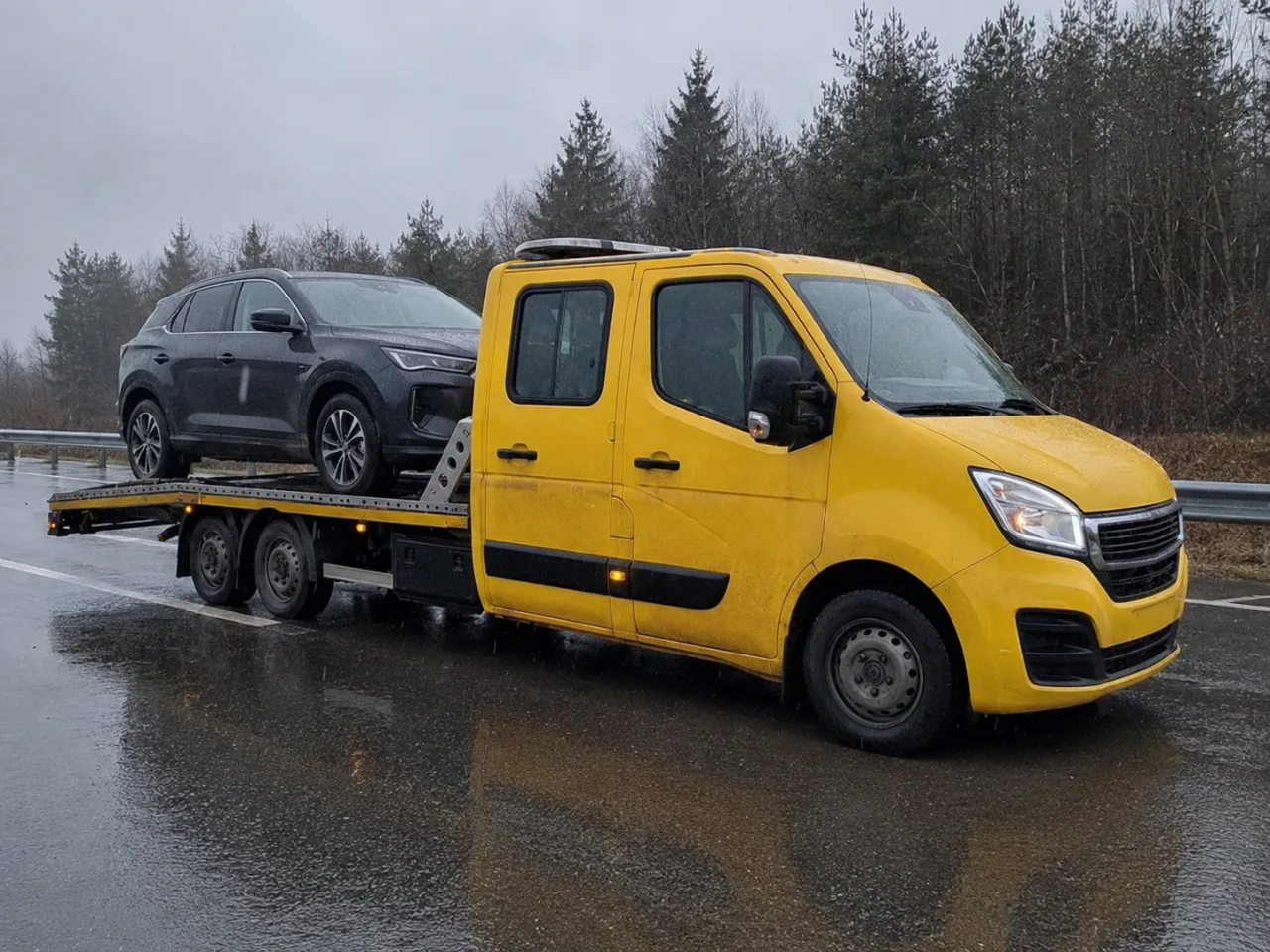 Holowanie srebrnego SUV-a na lawecie w deszczu – Piaseczno